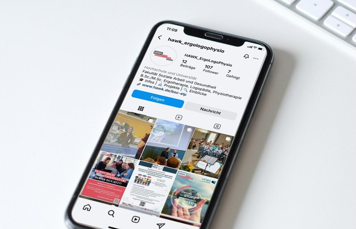 Smartphone mit geöffnetem Instagram Account der Studiengänge Ergo, Logo, Physio der HAWK